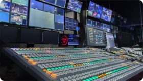 mixing console in front of computer monitors