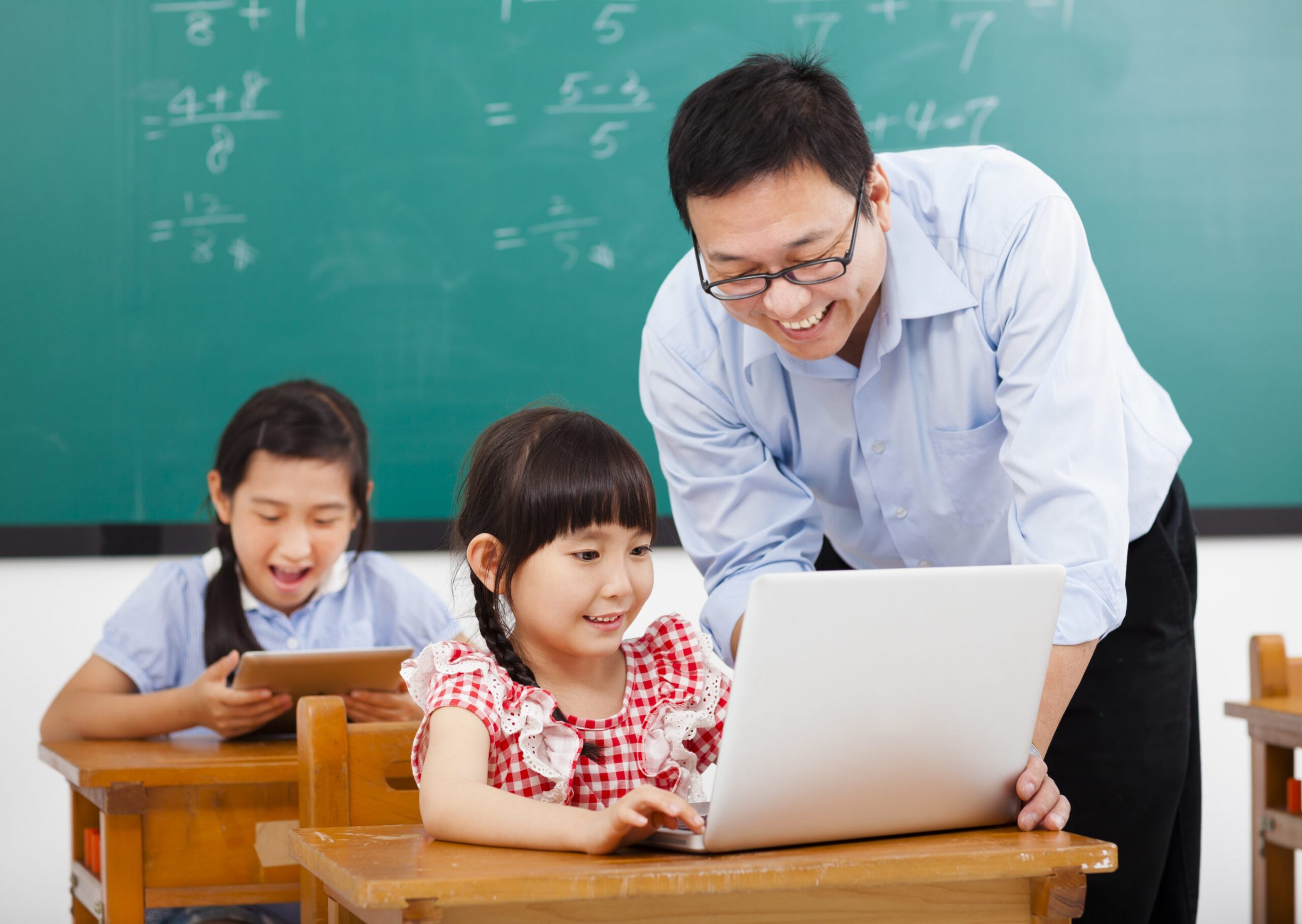 teacher teaching the computer with children in classroom