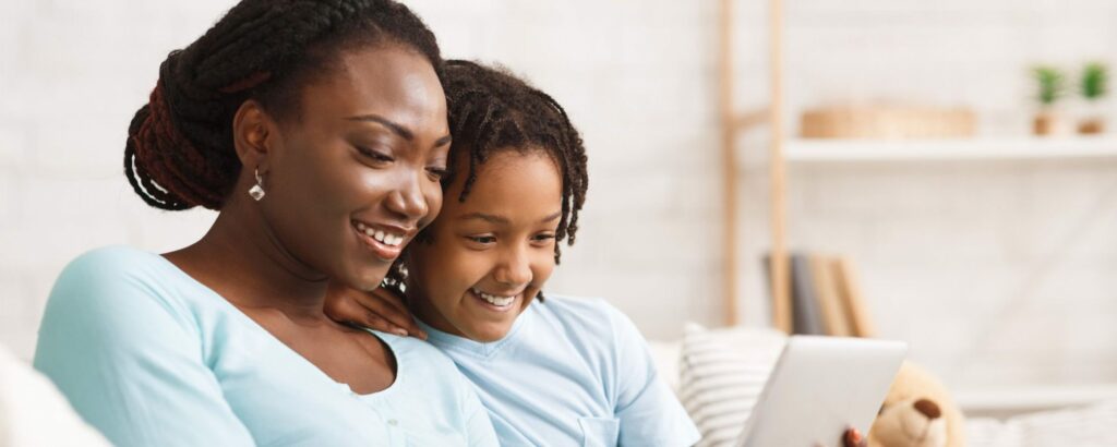 Black woman reading with Black child